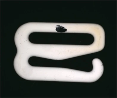 Source polarized-light capture: a dark irregular surface region is visible on the pale ceramic part.
