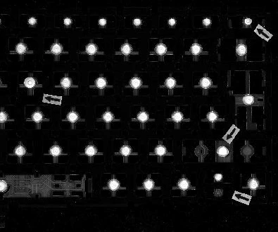 Source blue-bar capture: repeated bright circular contact features stand out against the dark mat and surrounding pattern.