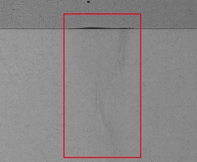 Conventional line-light capture of the label application; original red box retained.