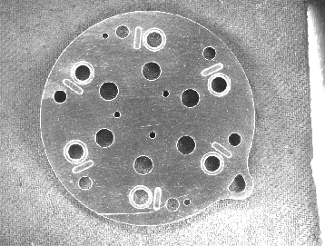 Camera capture with the white LS-4BRM230: scratches and hole rims return brighter than the surrounding surface.