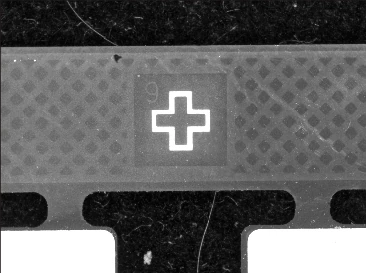 The reference cross is bright against the textured board region in the supplied capture.