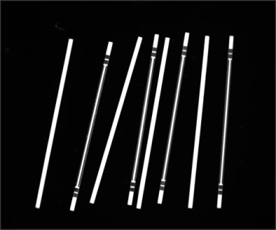 Source polarized-light capture showing slender metal parts with differing bright end and shoulder features.
