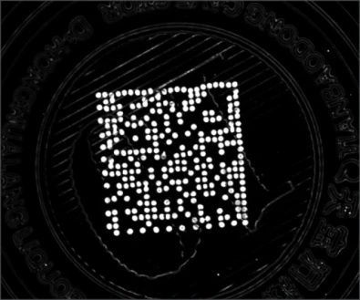 Source trial A: a dotted two-dimensional code appears bright against the dark cap under UV illumination.